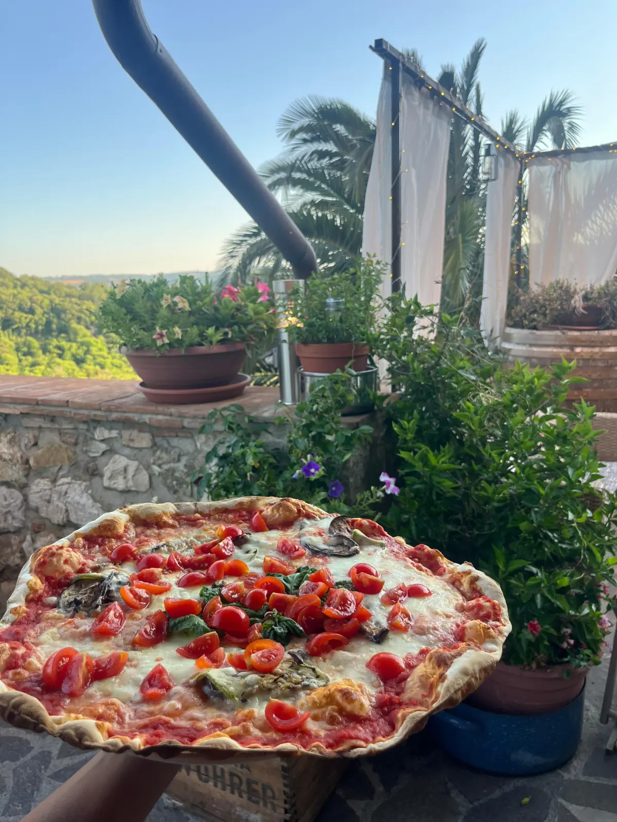 Pizza con pomodorini e basilico sulla terrazza panoramica